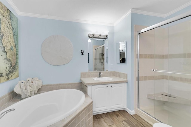 full bathroom with a stall shower, wood finished floors, a garden tub, crown molding, and vanity