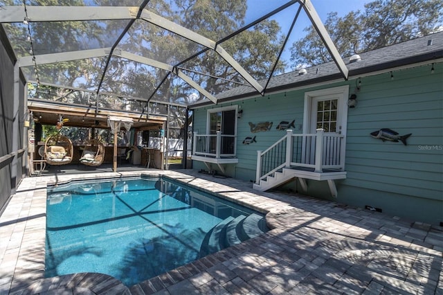 outdoor pool with glass enclosure and a patio