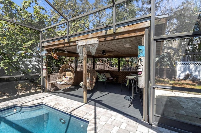 outdoor pool with ceiling fan, a wooden deck, and a lanai