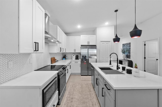 kitchen featuring a center island with sink, a sink, stainless steel appliances, wall chimney range hood, and backsplash