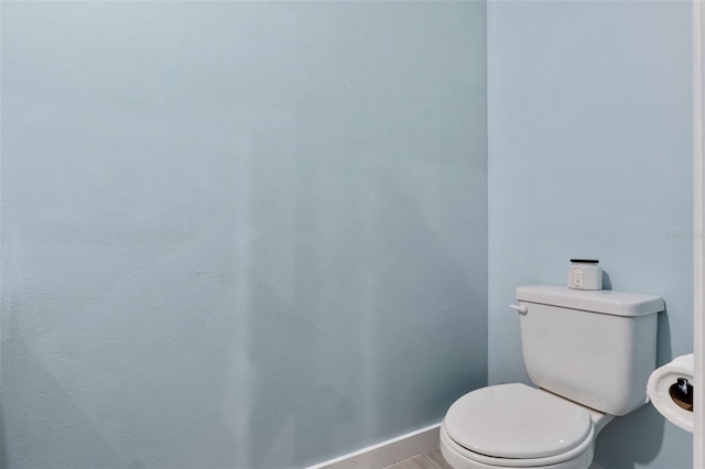 bathroom featuring baseboards and toilet