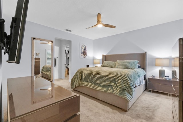 bedroom featuring a ceiling fan, visible vents, and light colored carpet