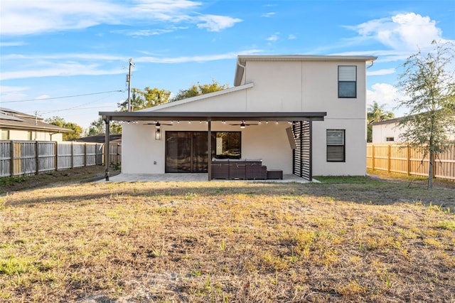 rear view of house with an outdoor hangout area, a fenced backyard, a ceiling fan, and stucco siding