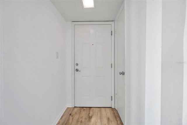 doorway to outside with light wood-style flooring and baseboards