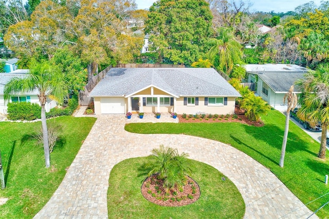 view of front of property with a garage, roof with shingles, decorative driveway, stucco siding, and a front yard