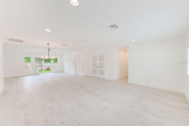 unfurnished living room featuring light wood-type flooring, an inviting chandelier, visible vents, and recessed lighting