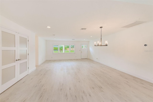 spare room featuring baseboards, visible vents, and light wood-style floors