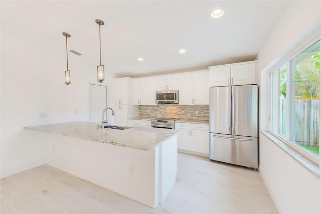 kitchen with white cabinets, backsplash, stainless steel appliances, and a sink