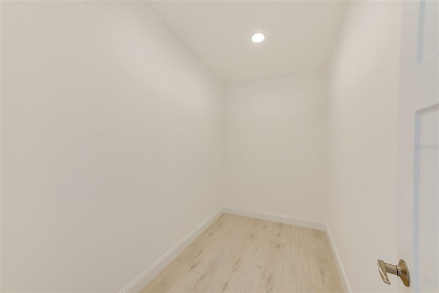 interior space with baseboards, wood finished floors, and recessed lighting