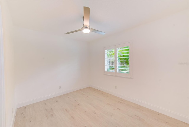 spare room with light wood-type flooring, ceiling fan, and baseboards