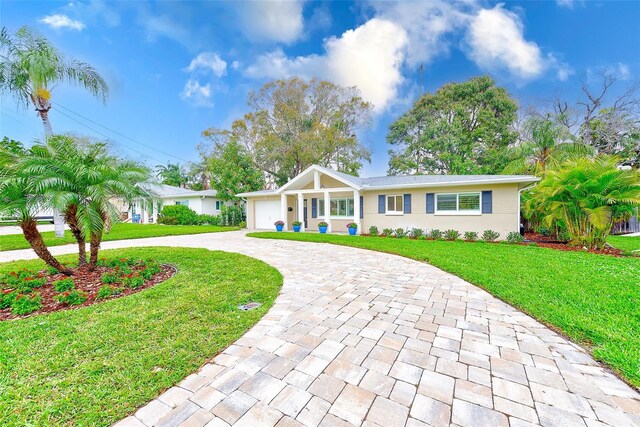 ranch-style home with an attached garage, driveway, and a front lawn