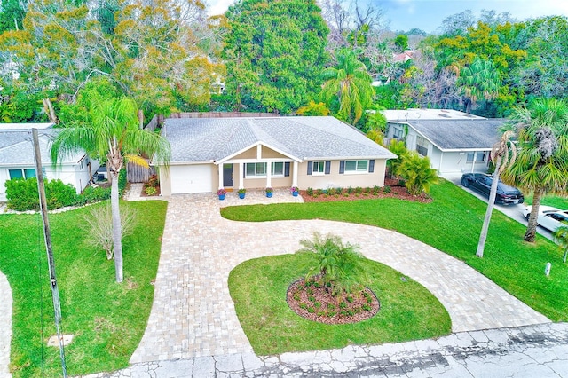 ranch-style house featuring a front yard, decorative driveway, roof with shingles, and stucco siding