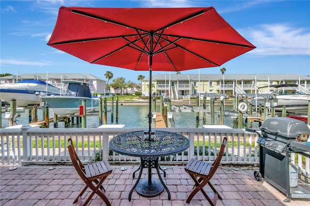 view of patio / terrace with a dock, area for grilling, boat lift, and a residential view