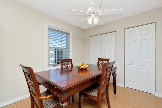 dining room with a ceiling fan, light wood-style flooring, and baseboards