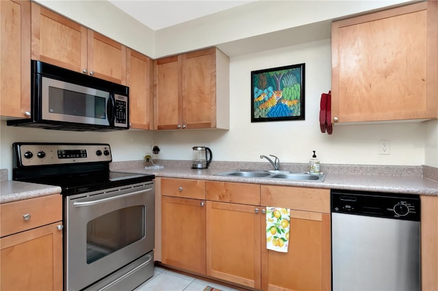 kitchen featuring stainless steel appliances, light countertops, a sink, and light tile patterned floors