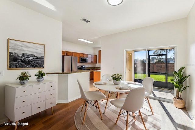 dining space featuring visible vents and wood finished floors