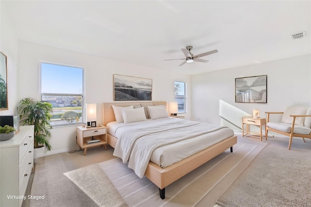 bedroom featuring light carpet, ceiling fan, visible vents, and baseboards