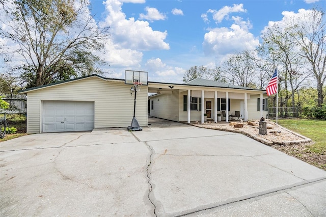 view of front of home featuring a garage, fence, concrete driveway, and an outbuilding