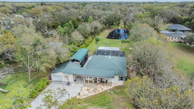 birds eye view of property featuring a water view and a wooded view