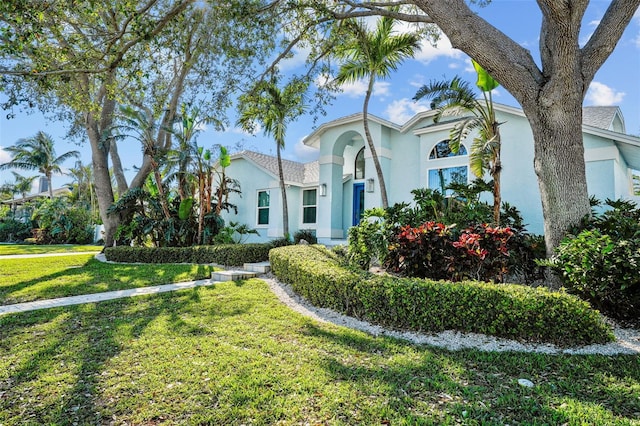 mediterranean / spanish-style house with a front lawn and stucco siding