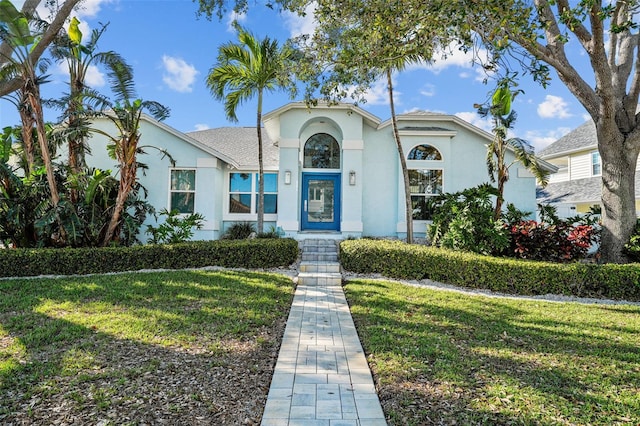 mediterranean / spanish-style home with a front yard and stucco siding