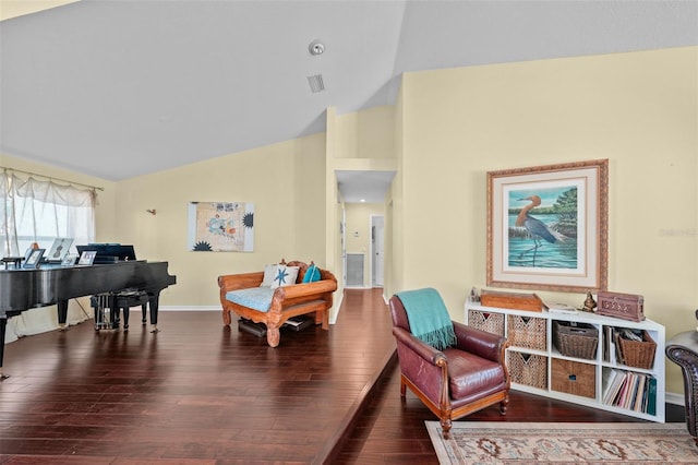 living area featuring vaulted ceiling, wood finished floors, visible vents, and baseboards