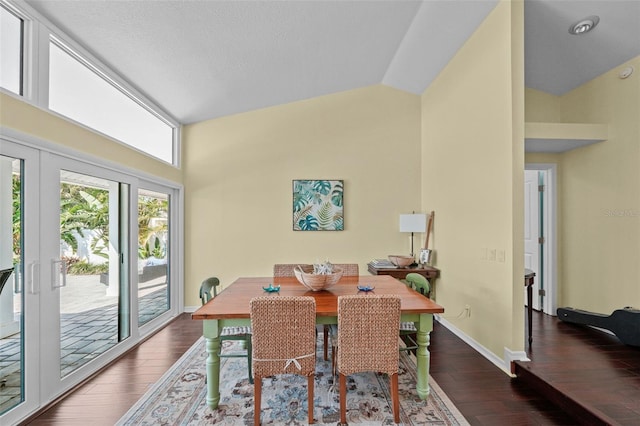 dining area with baseboards, vaulted ceiling, hardwood / wood-style floors, and french doors