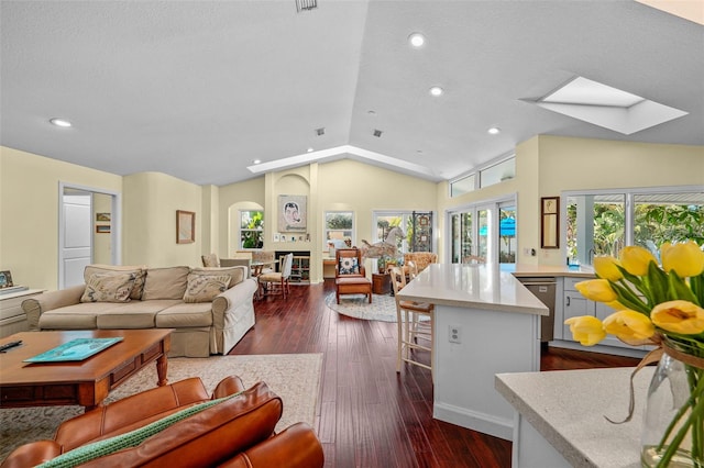 living area featuring lofted ceiling with skylight, dark wood-style floors, a textured ceiling, and recessed lighting