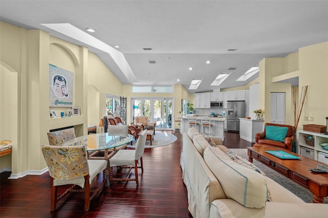 dining room with a skylight, baseboards, dark wood-style flooring, and recessed lighting