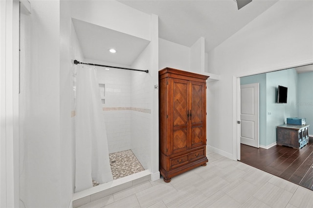 bathroom with baseboards and a tile shower