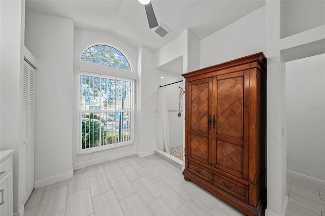 unfurnished bedroom featuring lofted ceiling, baseboards, multiple windows, and visible vents