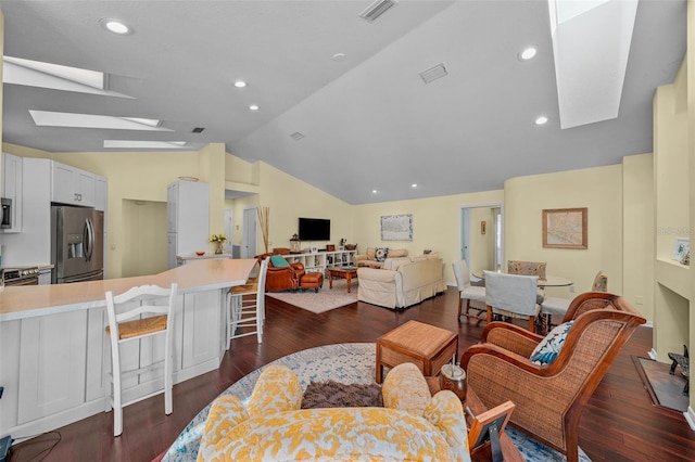 living room with lofted ceiling with skylight, visible vents, dark wood-style flooring, and recessed lighting