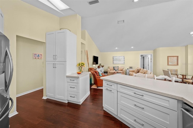 kitchen featuring visible vents, dark wood-style floors, open floor plan, light countertops, and stainless steel refrigerator with ice dispenser