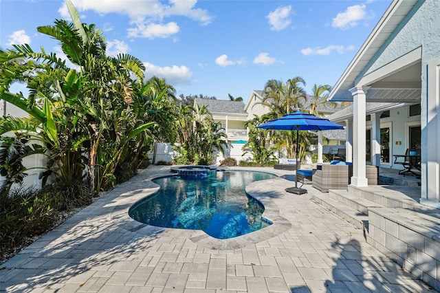 view of swimming pool featuring a patio area, a fenced backyard, and a pool with connected hot tub