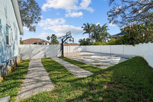 view of yard featuring basketball hoop and a fenced backyard