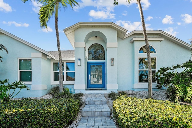 view of exterior entry with stucco siding