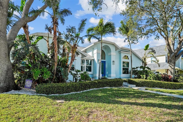 view of front facade with a front yard and stucco siding