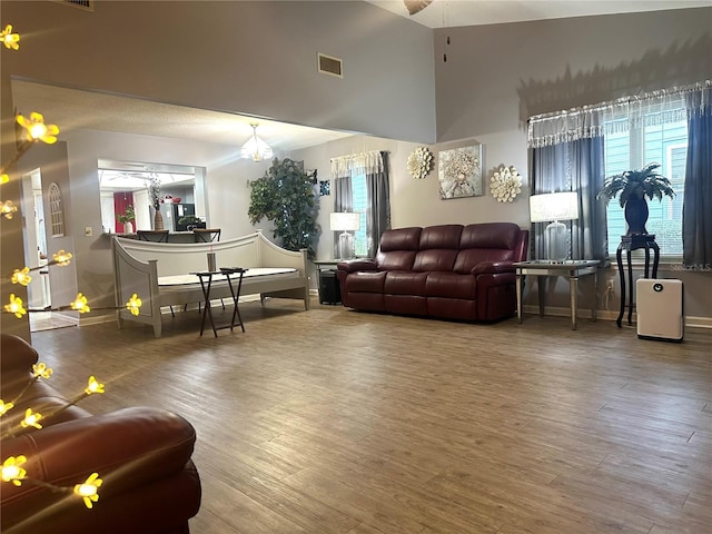 living area with visible vents, baseboards, and wood finished floors