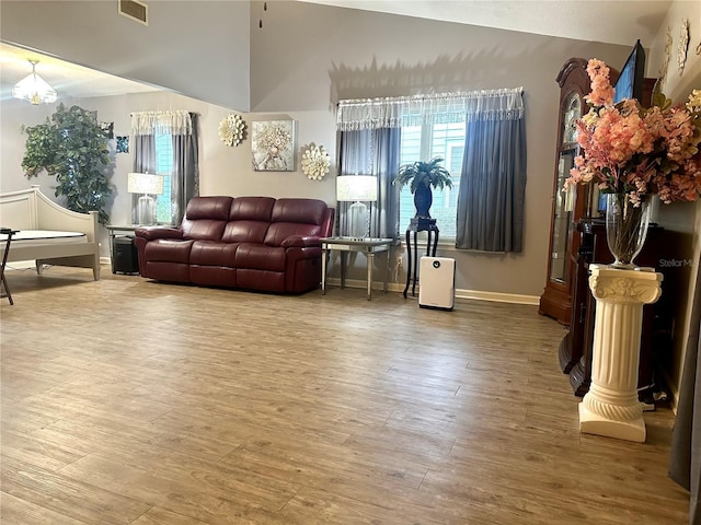 living room featuring visible vents, baseboards, and wood finished floors