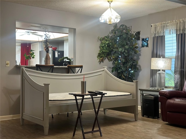 sitting room with a textured ceiling, wood finished floors, and baseboards