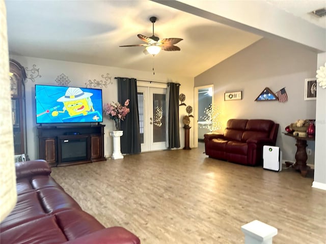 living area featuring visible vents, lofted ceiling, ceiling fan, wood finished floors, and a fireplace