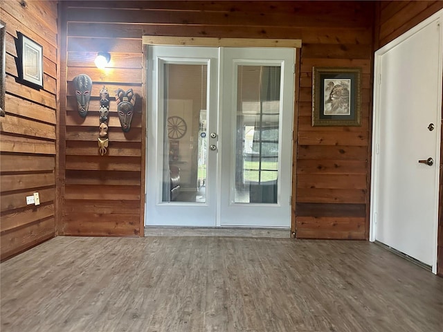 entryway with wood walls and wood finished floors