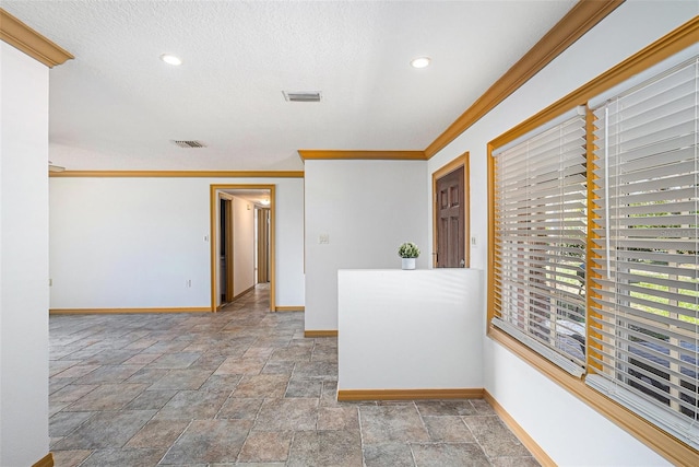 spare room featuring baseboards, visible vents, and crown molding