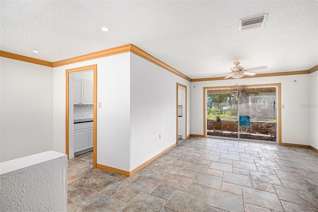 empty room featuring ornamental molding, a ceiling fan, visible vents, and baseboards