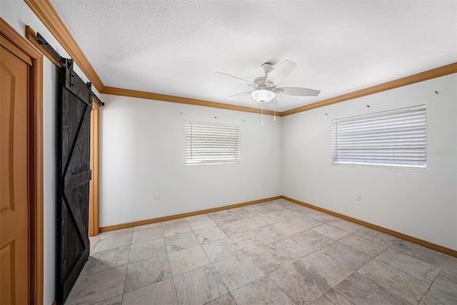 unfurnished bedroom featuring a barn door, a textured ceiling, ornamental molding, and baseboards