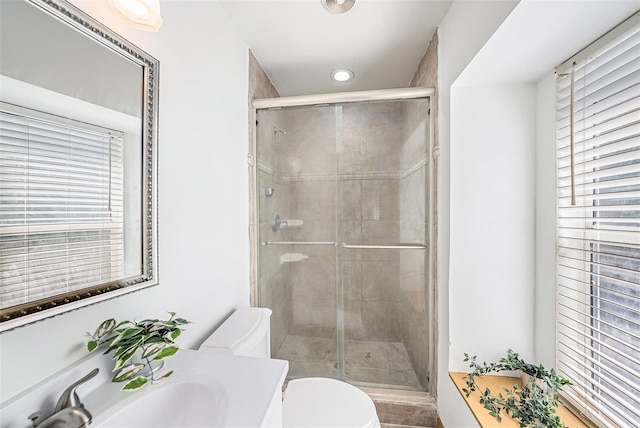 full bath with vanity, a shower stall, and toilet