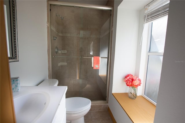 bathroom with a stall shower, vanity, toilet, and tile patterned floors