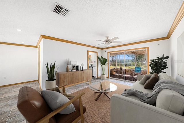 living area featuring baseboards, visible vents, ceiling fan, ornamental molding, and a textured ceiling