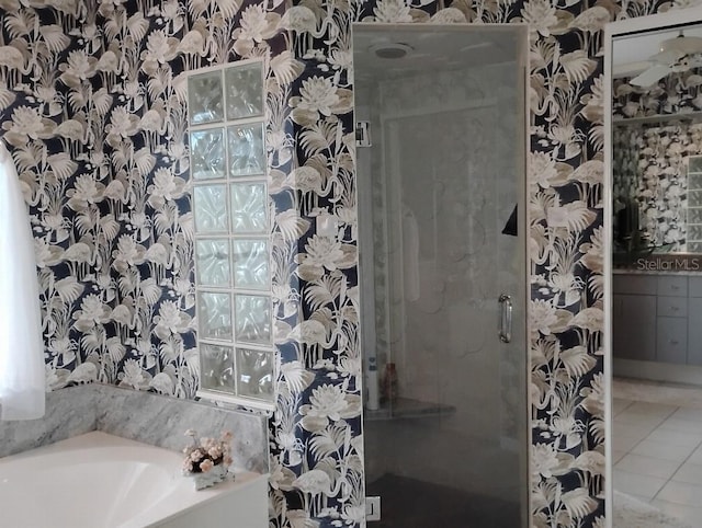 full bathroom featuring tile patterned floors, a shower stall, a bath, and wallpapered walls