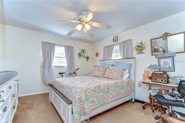 bedroom with a ceiling fan, light colored carpet, baseboards, and multiple windows